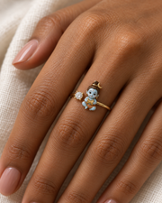 Bal Shiva Damru ring – sky-blue enamel baby Shiva holding a damru beside a lab grown diamond solitaire, worn on the ring finger