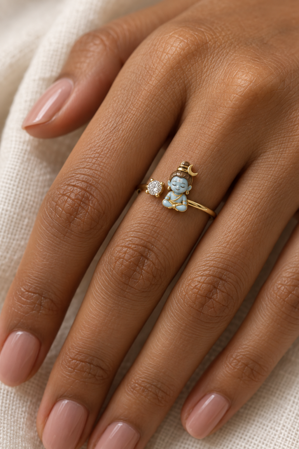 Bal Shiva Dhyan ring – sky-blue enamel baby Shiva seated in meditation beside a lab grown diamond solitaire, worn on the ring finger