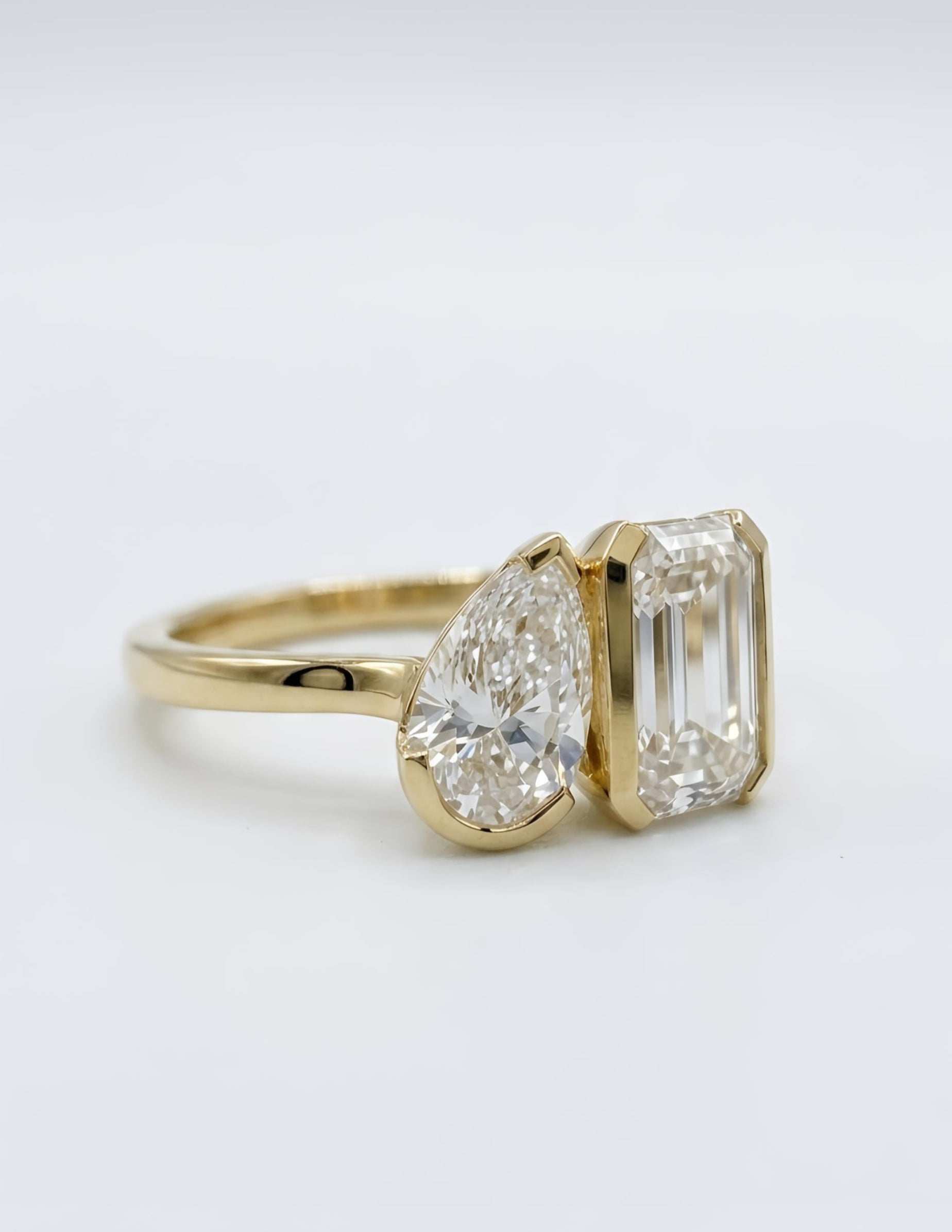 Close-up of Aura Nexus Emerald & Pear Lab Diamond Toi Et Moi Ring set in 14K Yellow Gold by Fiona Diamonds
