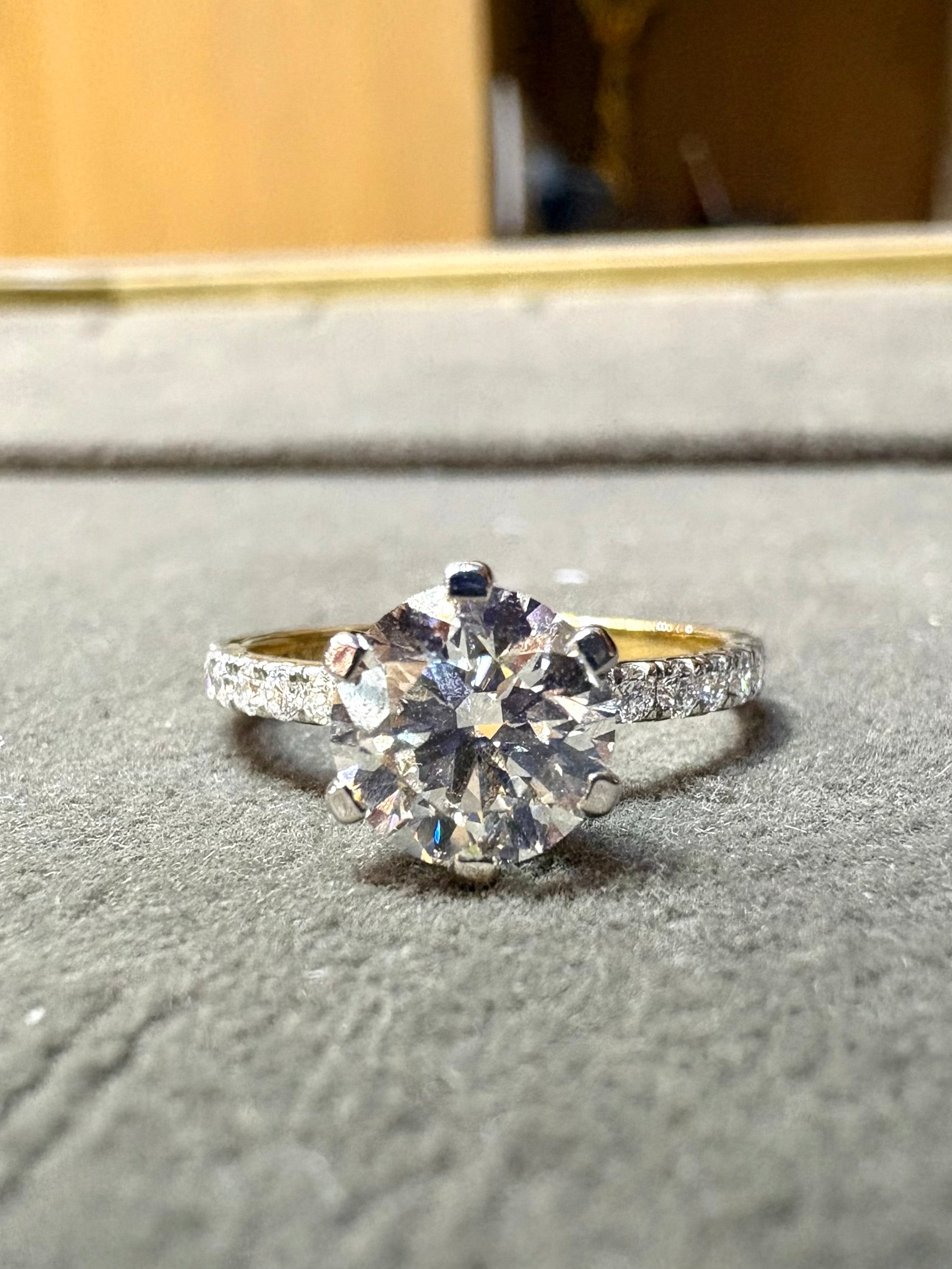 Close-up of Kaelith Lace Round Lab Diamond Side Stone Solitaire Ring set in 18K Yellow Gold by Fiona Diamonds