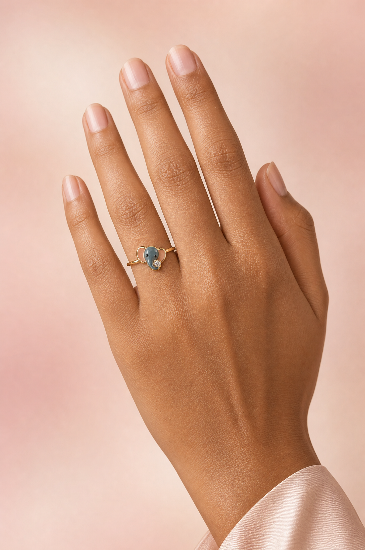 Belina Peekaboo ring – front-facing blue-grey enamel baby elephant with blush-pink ears and a lab grown diamond at its trunk, worn on the ring finger