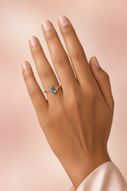 Belina Peekaboo ring – front-facing blue-grey enamel baby elephant with blush-pink ears and a lab grown diamond at its trunk, worn on the ring finger