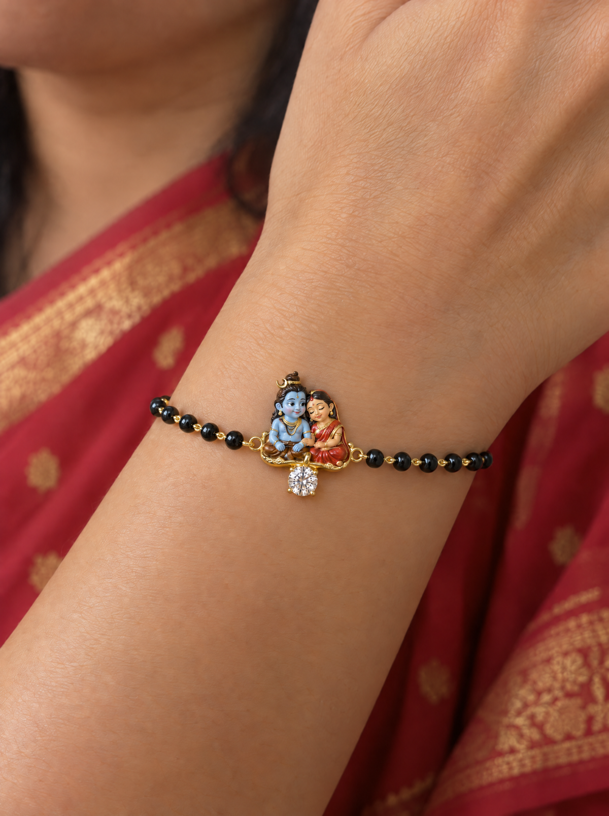 Saath Shiv Gauri hand mangalsutra – enamel baby Shiva and Gauri seated together on a gold base with a lab grown diamond drop, black bead chain worn on the wrist
