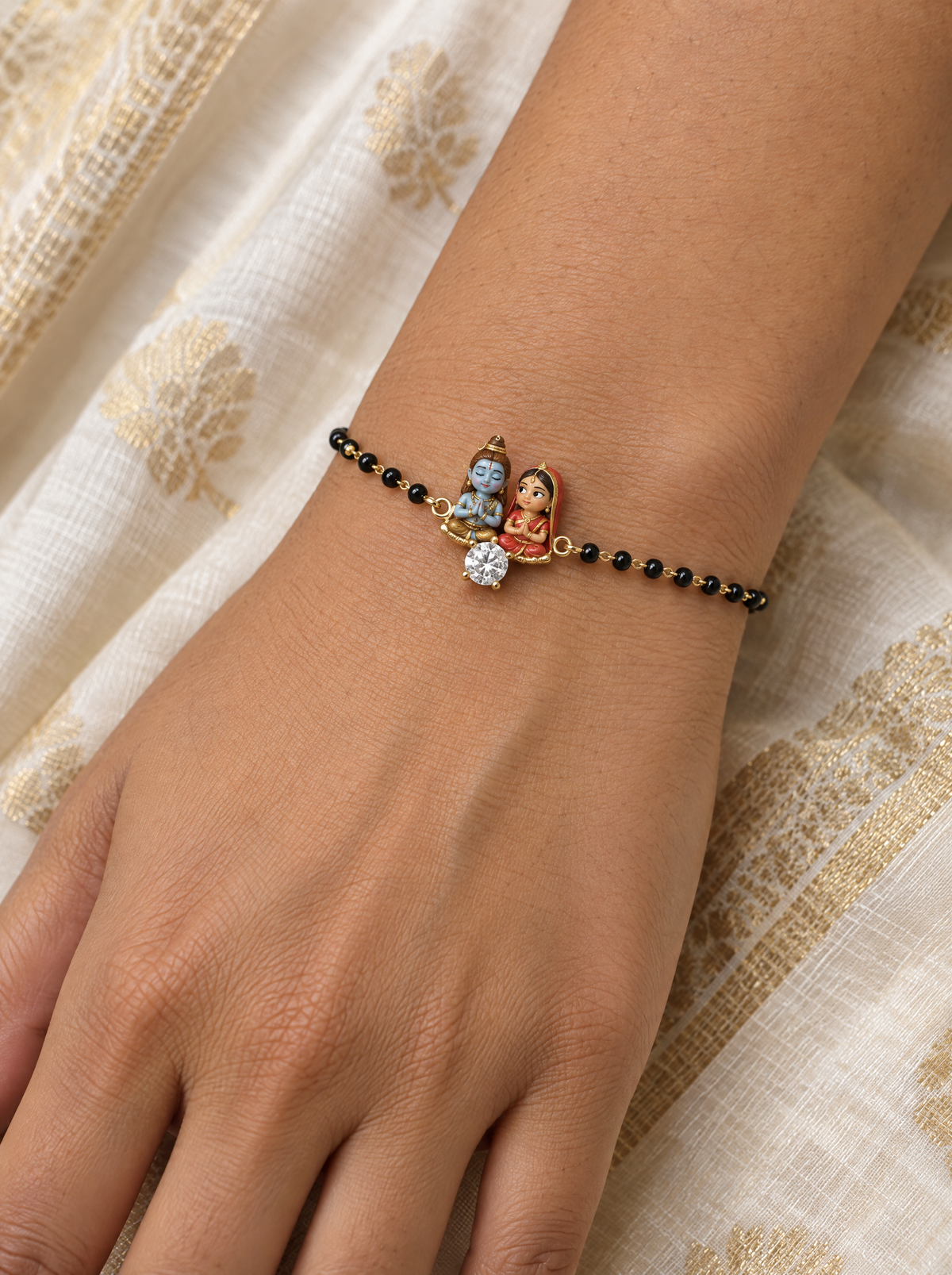 Aradhana Shiv Gauri hand mangalsutra – enamel baby Shiva meditating and Gauri praying with a lab grown diamond solitaire in front, black bead chain on the wrist